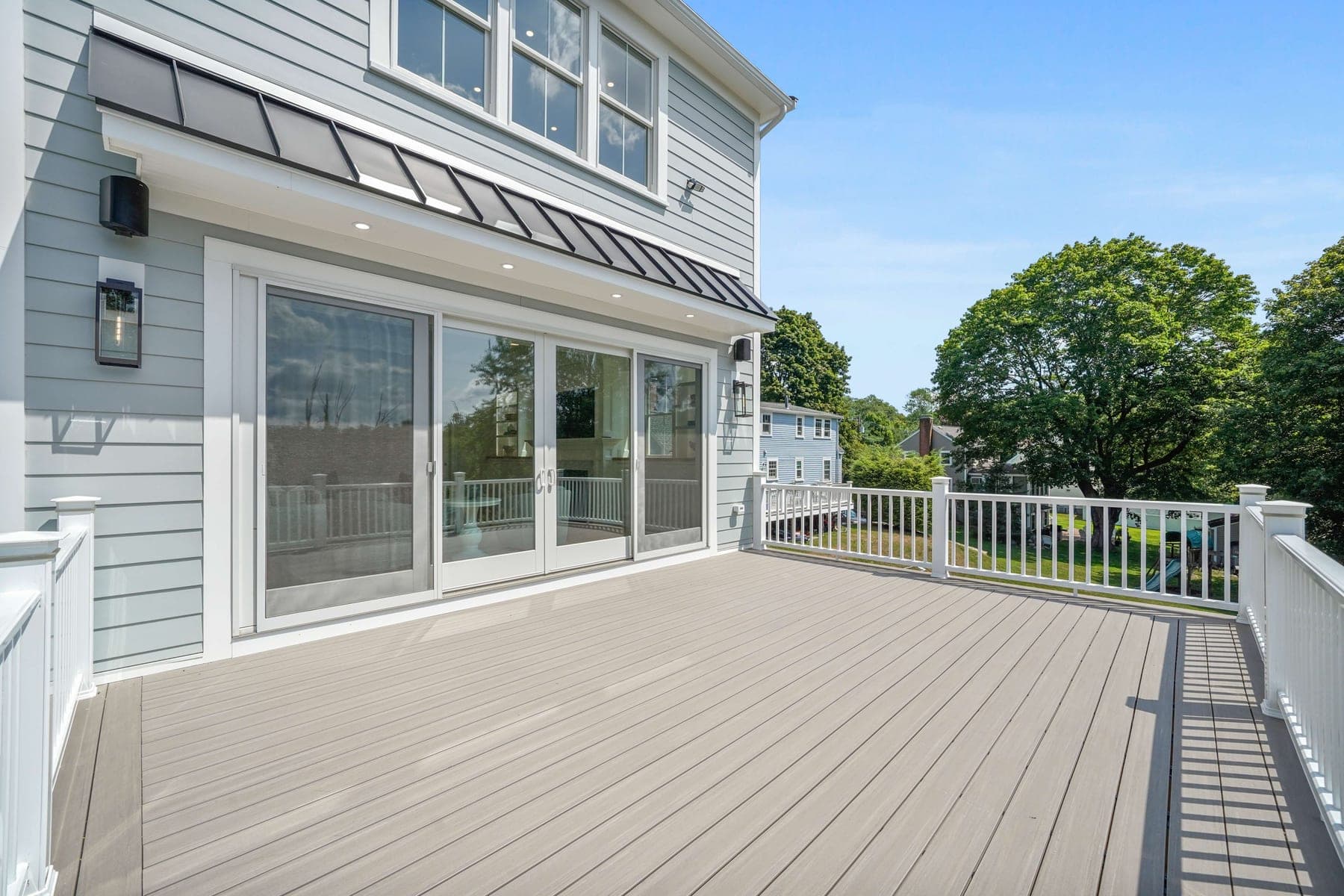 Rear deck with a wall of sliding glass doors and metal awnings for seamless indoor-outdoor living