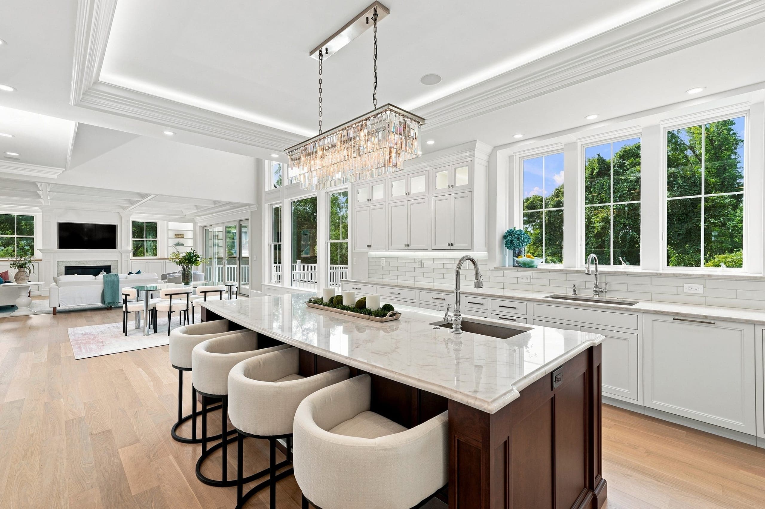 View from the kitchen through the open living space toward the family room and its summer greenery views