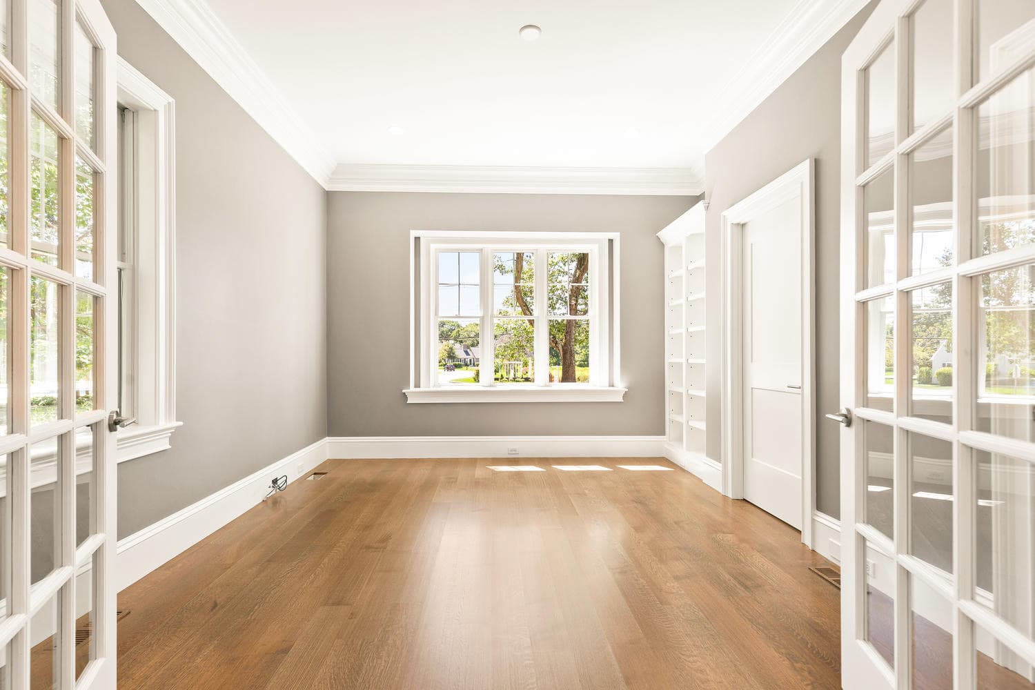 Study with gray walls, French door entry, and built-in bookcase
