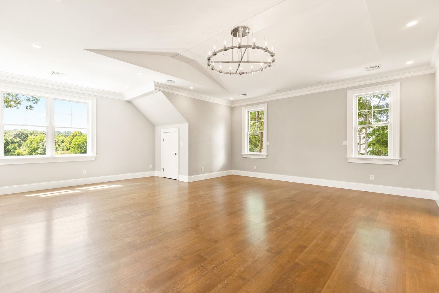 Third-floor bonus room with vaulted cathedral ceiling, round chandelier, and sweeping tree-top views