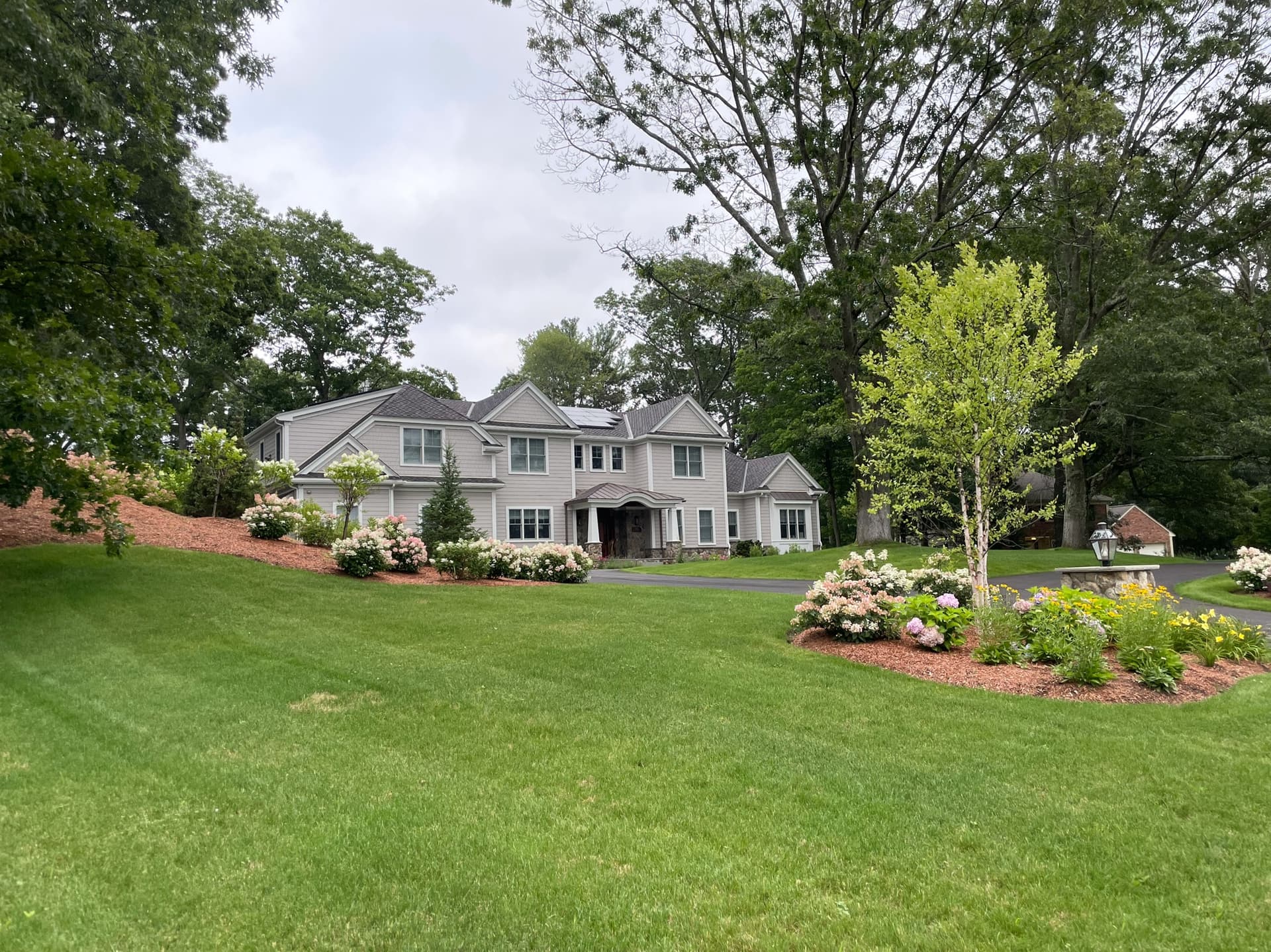 130 East Street — gray shingle exterior with hydrangea garden and mature landscaping