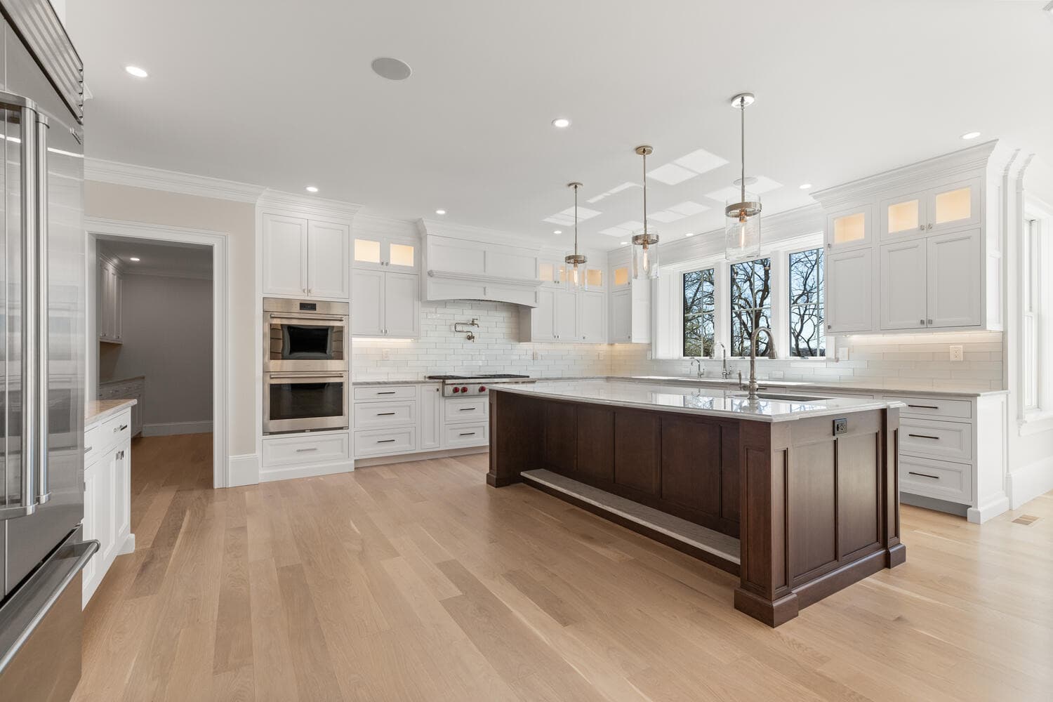Kitchen wide view showing open flow to great room with coffered ceilings