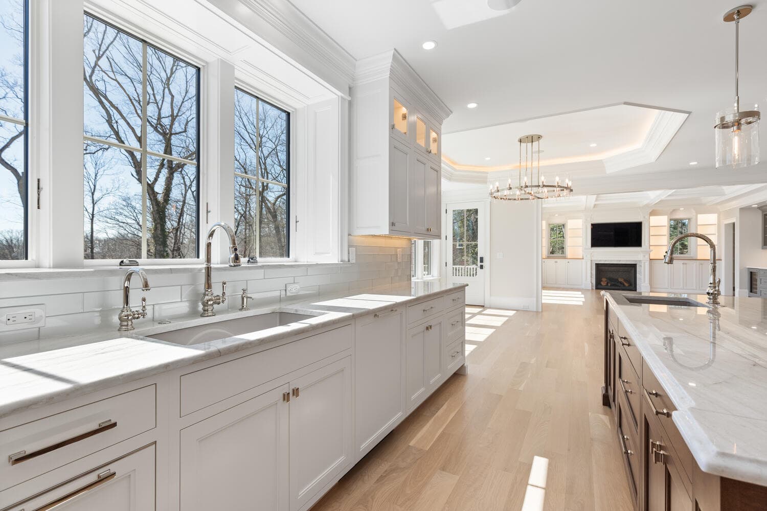 Kitchen prep area with marble countertops, pot filler, and view to great room