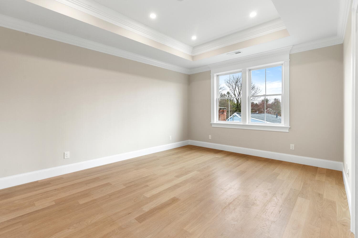 Second floor bedroom with coffered ceiling, Andersen windows, and wainscoting