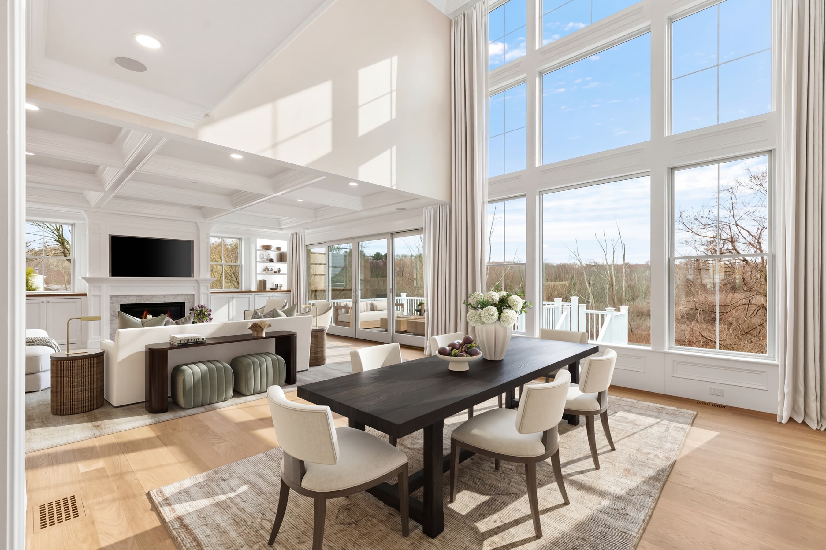 Two-story great room with massive windows, dining area, and conservation views — virtually staged