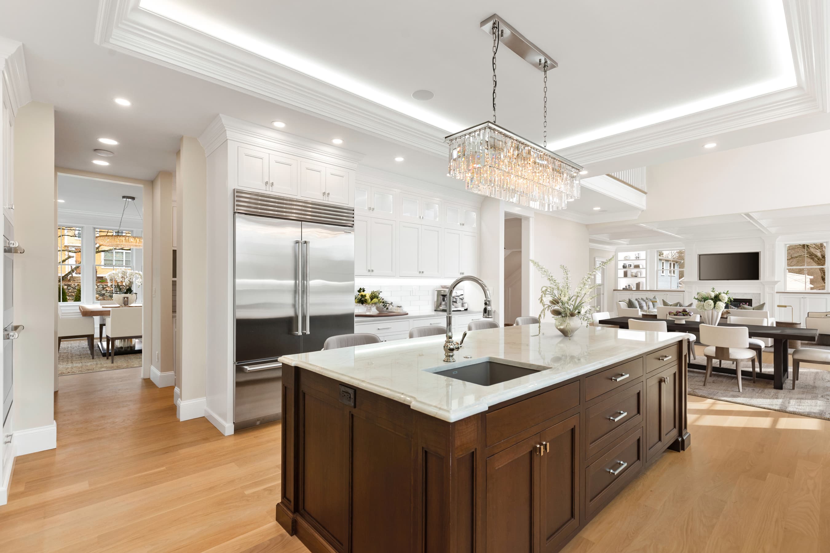 Kitchen island with cherry cabinetry, marble counters, and open floor plan — virtually staged